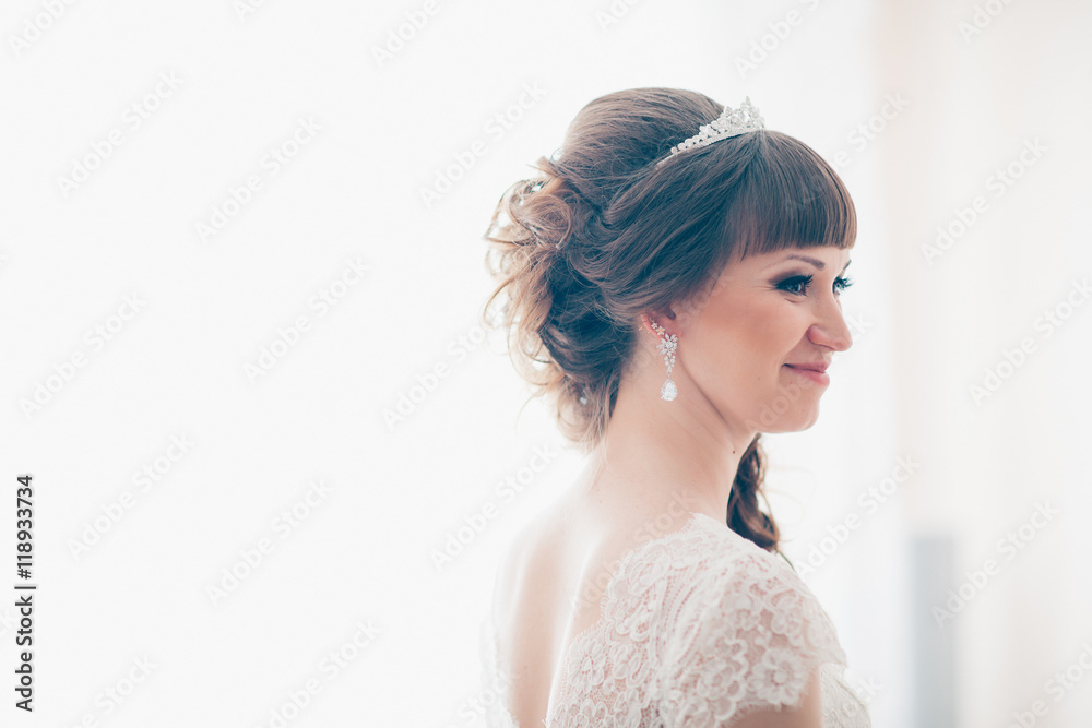 young bride smiling and standing near a window