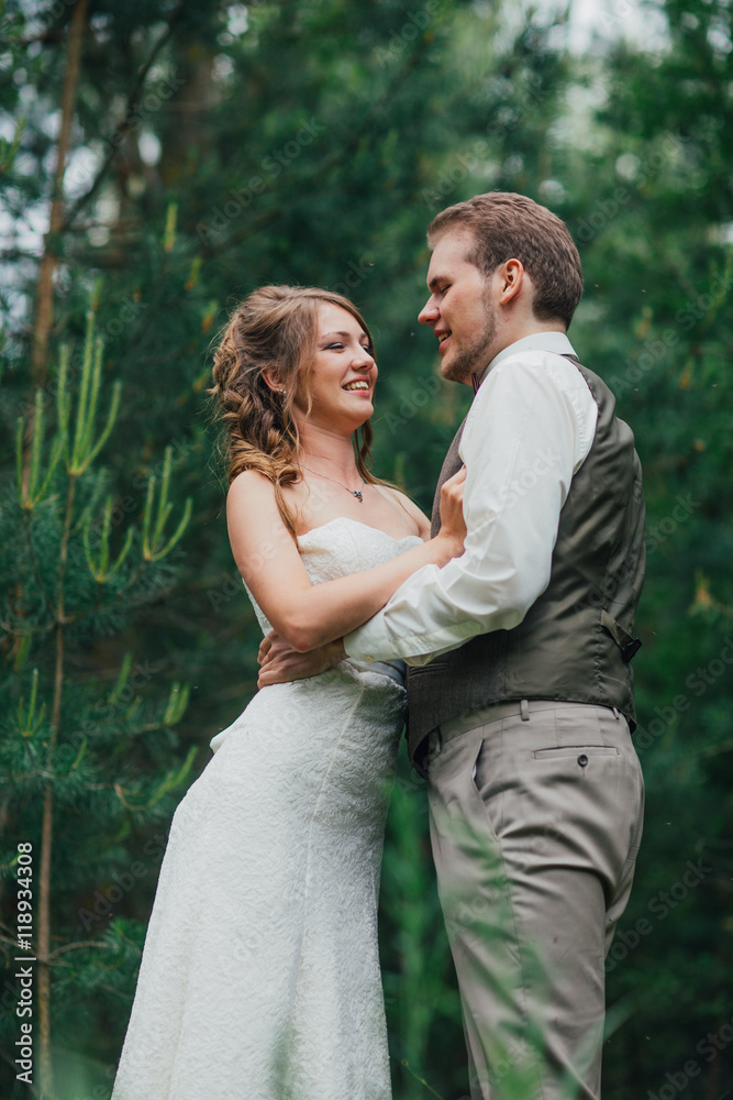Bride and groom are embracing against the background forest Bride and groom are embracing against the background forest
