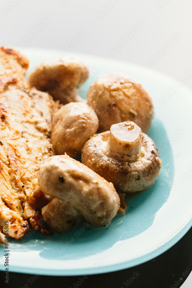 chicken with mushrooms in cream sauce on a blue plate chicken with mushrooms in cream sauce on a blue plate