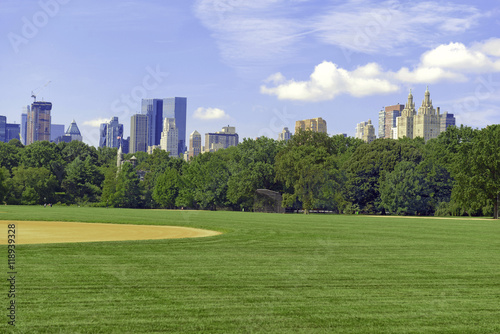 Green grass and baseball field of Central Park with Manhattan skyline and blue sky © nyker