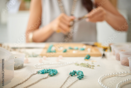 Woman creating her line of necklaces, selective focus