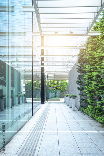 empty footpath before modern office building with sunbeam