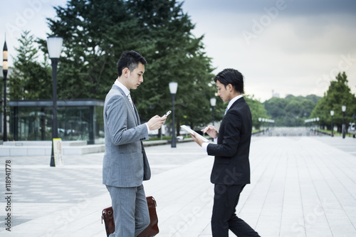Businessman is using a mobile phone while walking