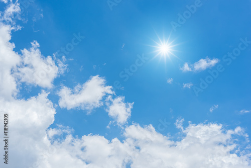 Blue sky with clouds and sun reflection. looking up view