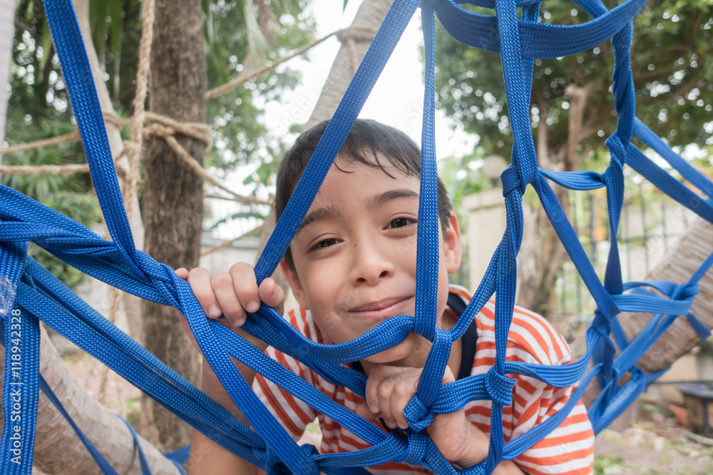 Kid climbing on the tree with rope net outdoor activity Kid climbing on the tree with rope net outdoor activity