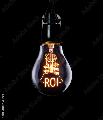 Hanging lightbulb with glowing Return on Investment concept. photo