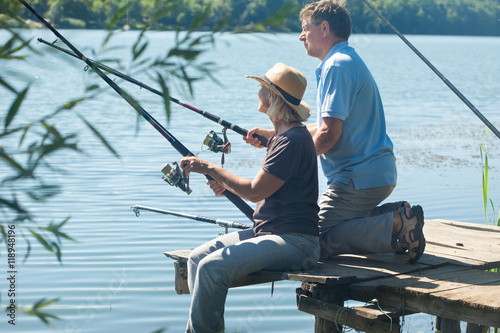 Man and woman on pontoon with fishing rods
