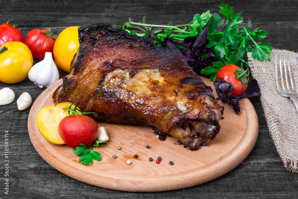 shin, knee wild boar - roast pork leg with vegetables on black background shin, knee wild boar - roast pork leg with vegetables on black background