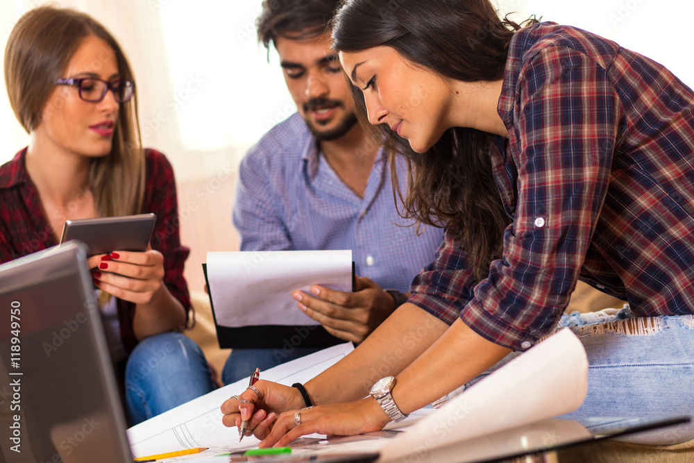 Obraz premium Teamwork. Three young architects working on a project. Startup concept.