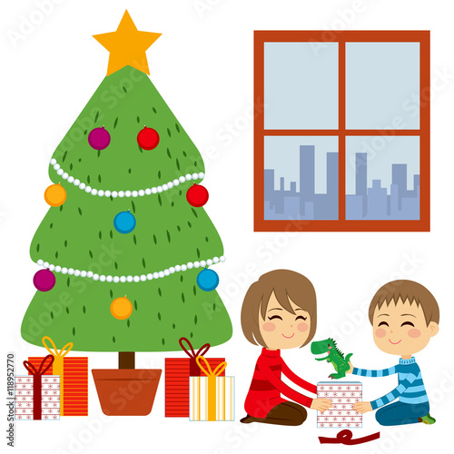 Two cute happy siblings children opening gifts together from Christmas Tree