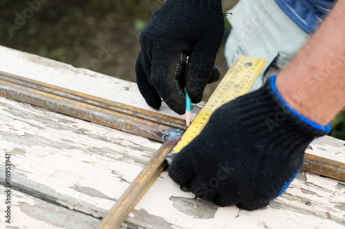 Worker in protective gloves constructing artwork from metal clos photo