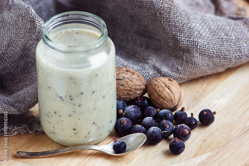 Yogurt with berries and nuts in a glass jar for healthy morning meal, selective focus