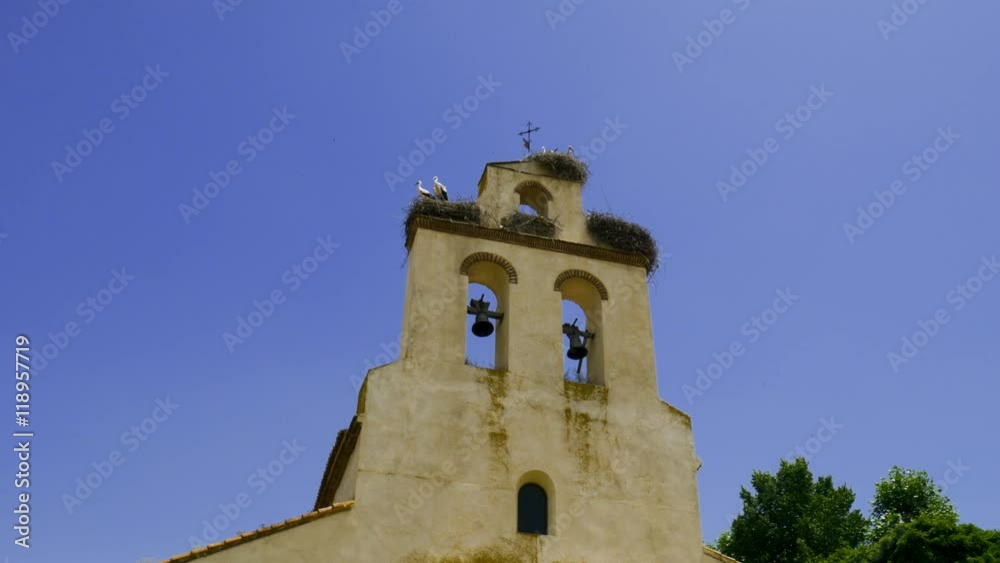 4k, Small beautiful church in rural Spain, Spring time. Storks nesting on a church in spring, Cranes mating on bell tower. 4k, Small beautiful church in rural Spain, Spring time. Storks nesting on a church in spring, Cranes mating on bell tower.