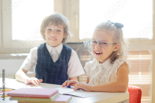 Small disciples sit at a school desk.