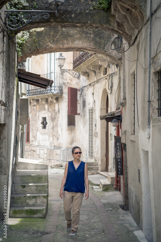 Tourist walking dow an old italian alley in Vico del Gargano, Apulia, Italy