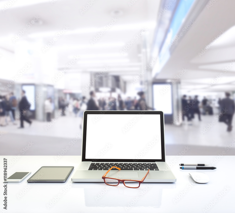 Laptop computer with blurred image of shopping mall background Laptop computer with blurred image of shopping mall background