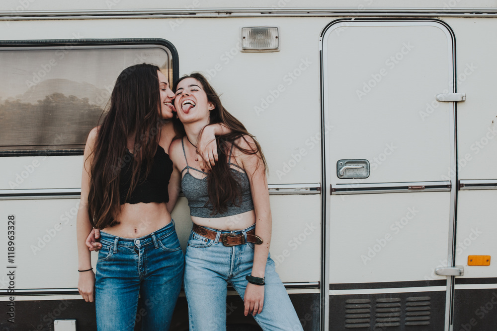 Young girls hugging and sticking out tongues