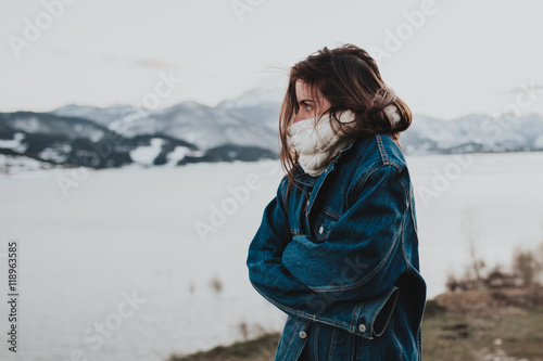 Young brunette woman cold at winter riverside