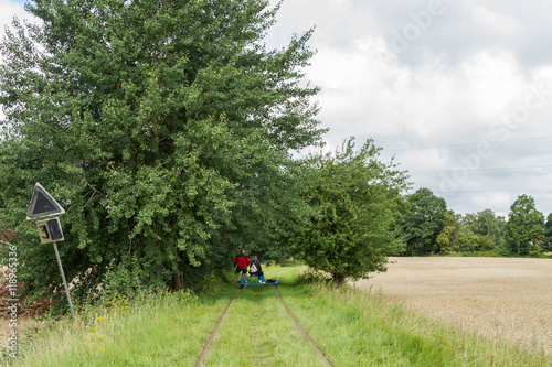 Man och kvinn cyklar dressin på nedlagd järnväg photo