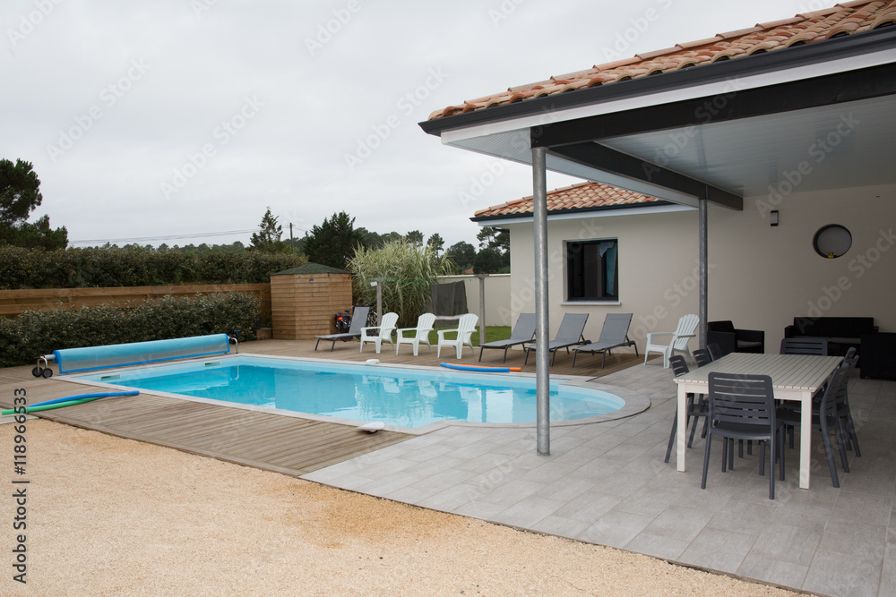 Rear garden of a contemporary home with tiled swimming pool