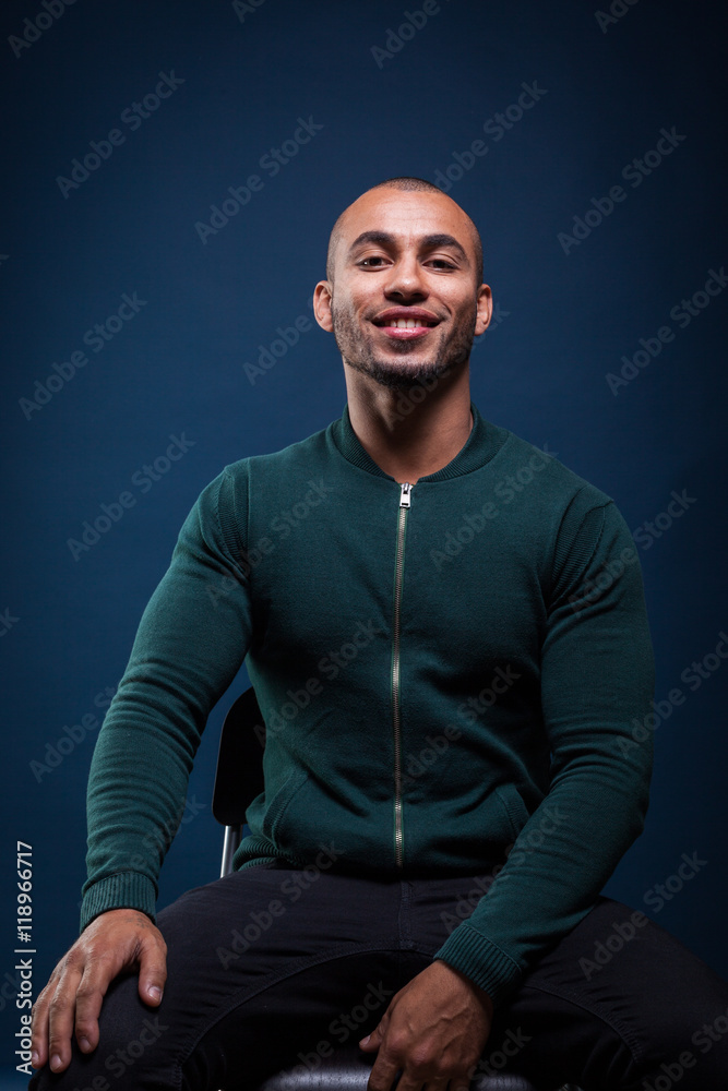 Portrait of an african american man smiling on dark blue background