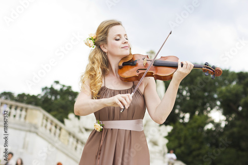 Photography Beautiful smiling girl playing on the violin outdoors