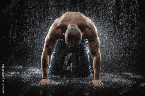 very muscular handsome athletic man in the rain