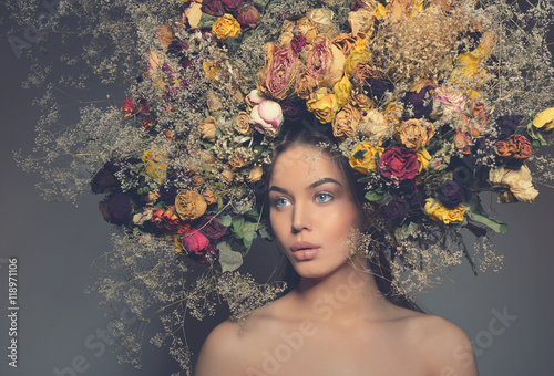Beauty fashion female portrait with large garland dried flowers.
