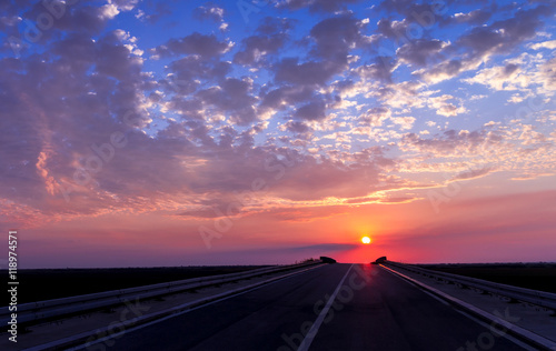 Sunset over the horizon and the road © sarenac77