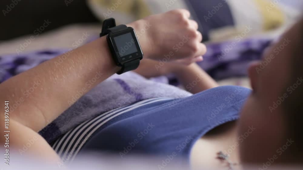 Woman Lying in Bed Woken Up by Alarm Clock App on Smart Watch