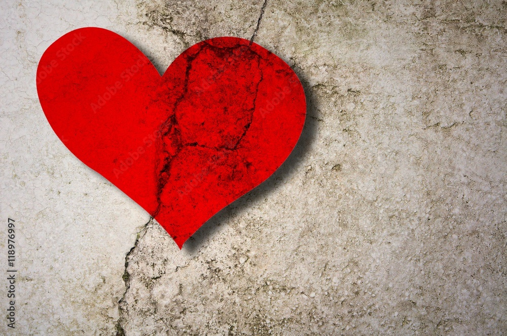 Cracked red heart on concrete wall Cracked red heart on concrete wall