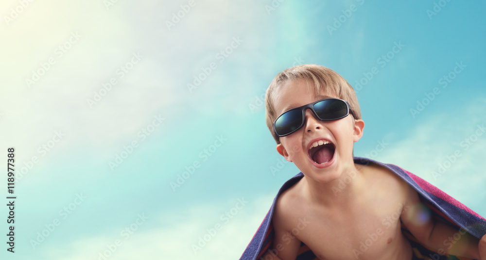 Boy wrapped in beach towel in summer sunshine Boy wrapped in beach towel in summer sunshine