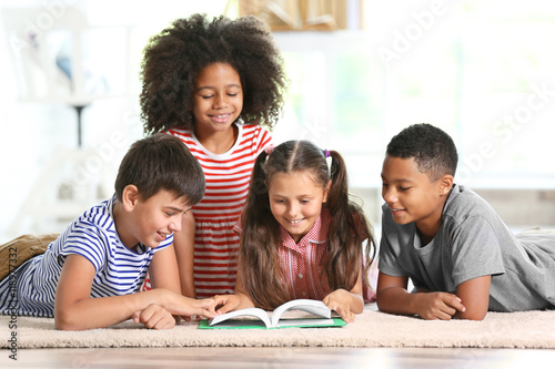 Cute kids reading book at home