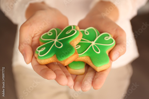 Woman holding decorative cookies. Saint Patrics Day concept