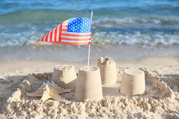 Sand castle with American flag on beach