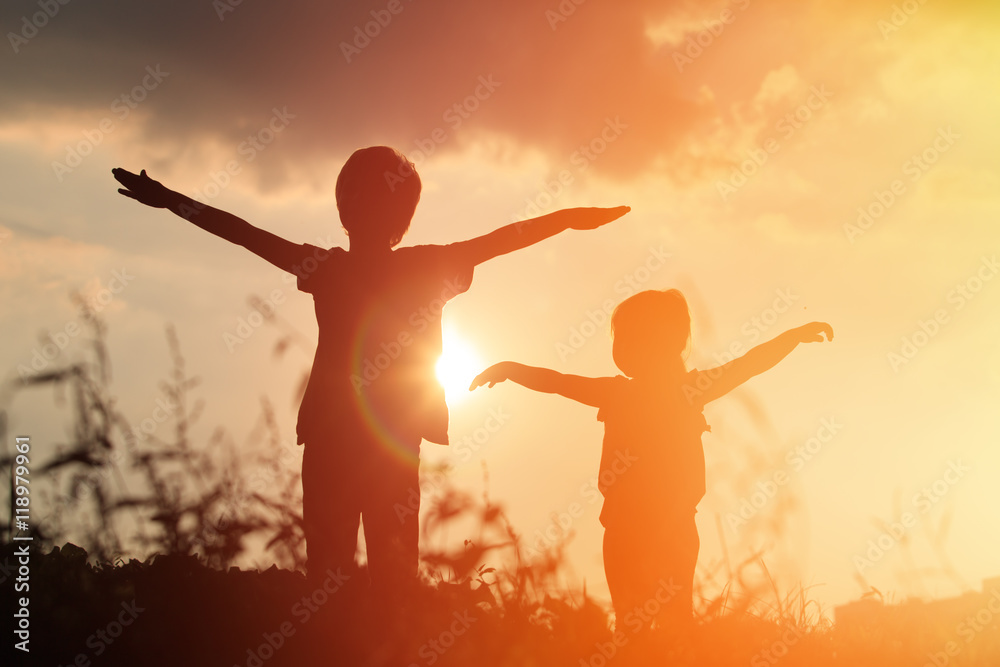 little boy and girl silhouettes play at sunset little boy and girl silhouettes play at sunset