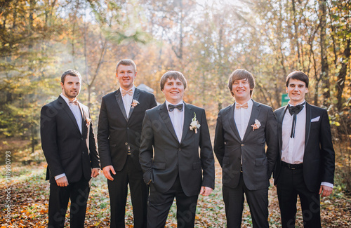 young groom and his funny friends groomsman posing for camera. Group of young men with bow tie. Cheerful friends. friends outdoors. Wedding day.