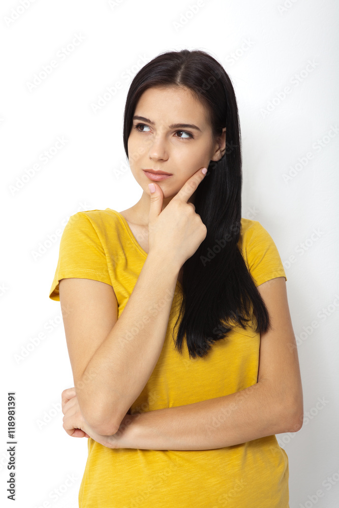 Portrait of an attractive young brunette woman ooking up dreaming.