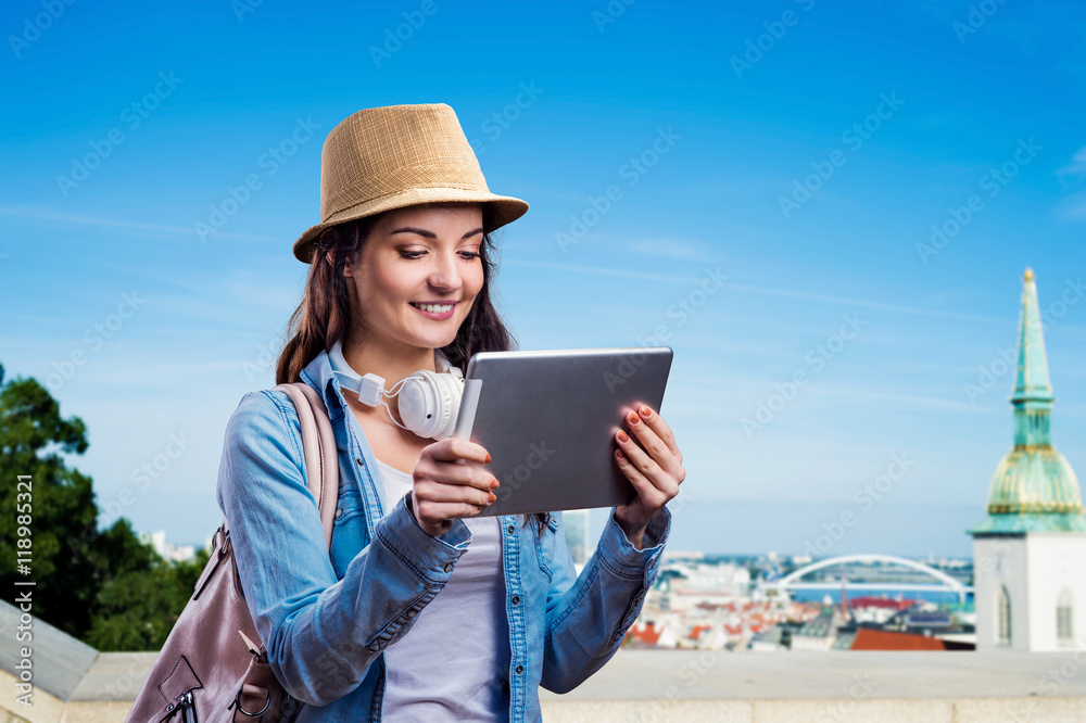 Fototapeta premium Tourist girl in denim shirt with tablet. Summer city.