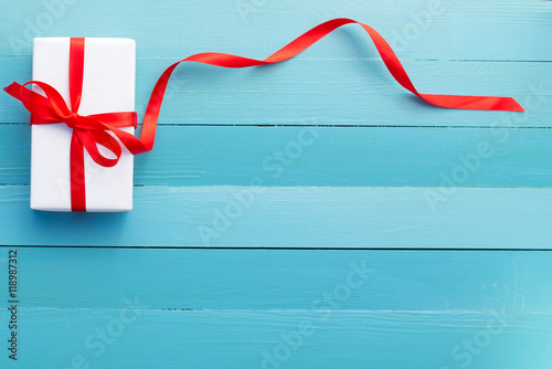 gift in white packing and a red ribbon photo