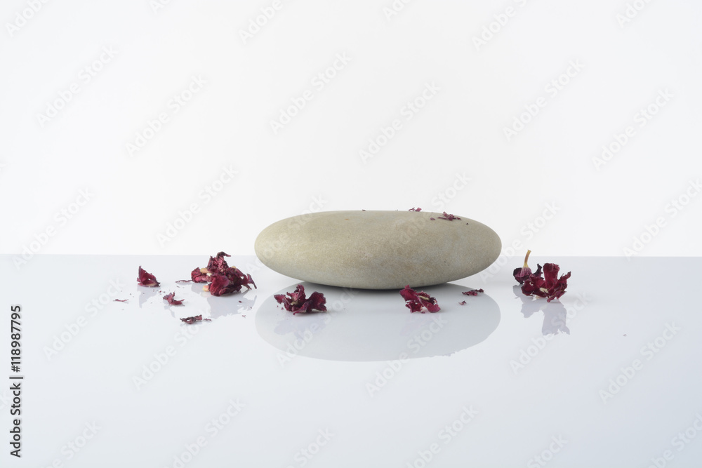 Fototapeta premium Piedras sobre fondo blanco y una flor de color rosa