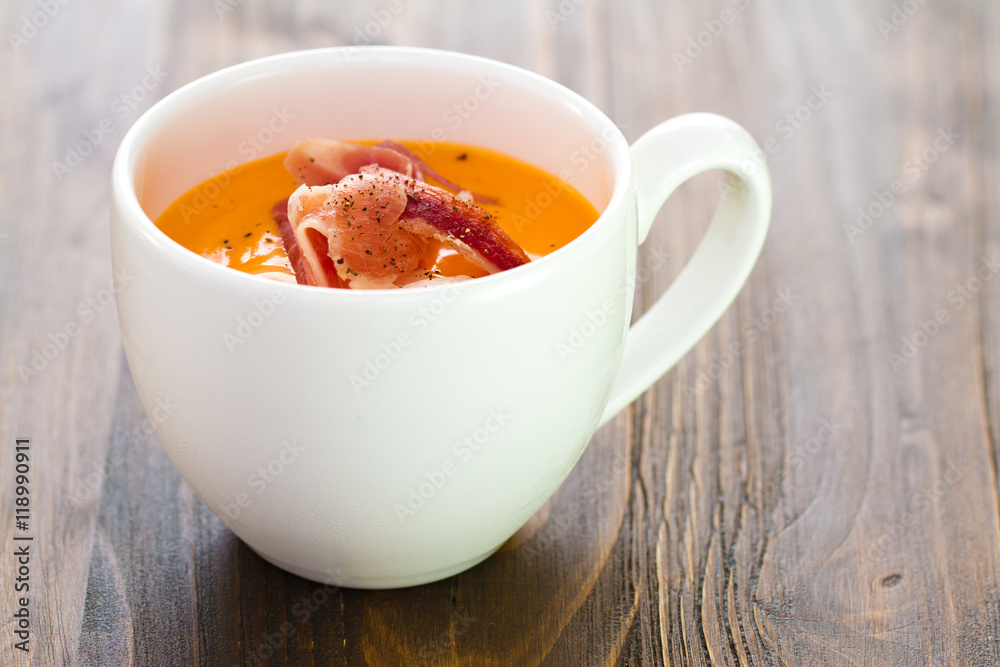 cold soup with smoked meat in white cup on brown wooden background cold soup with smoked meat in white cup on brown wooden background