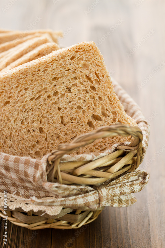 bread in basket on brown wooden background