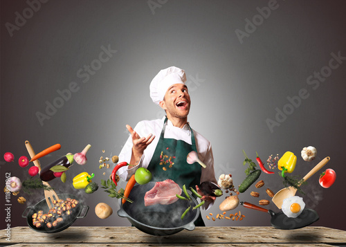 Chef juggling with vegetables and other food in the kitchen photo