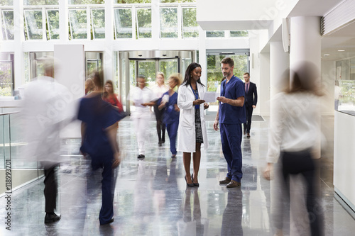 Staff In Busy Lobby Area Of Modern Hospital