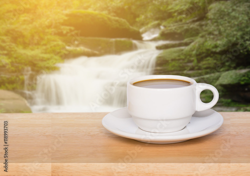 wood table coffee cup with blur waterfall background