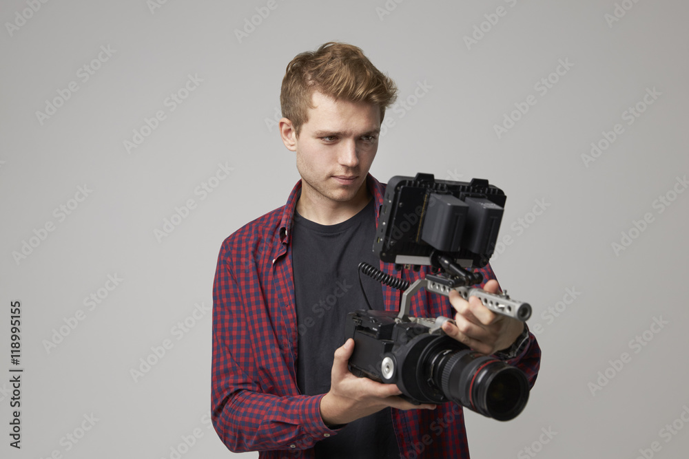 Obraz premium Studio Portrait Of Male Videographer With Film Camera