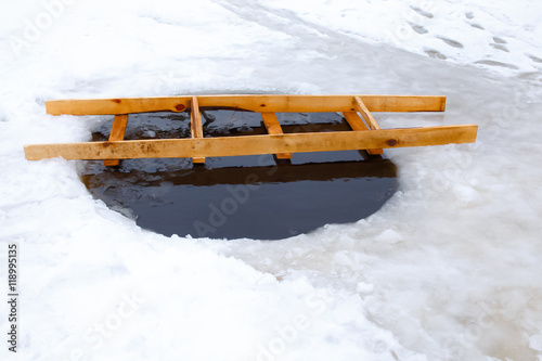 Epiphany. ice hole with a wooden ladder. hole in the ice for winter swimming outdoors. ice hole equipped with a wooden ladder across the hole. the Russian Orthodox tradition © EvgeniiAnd
