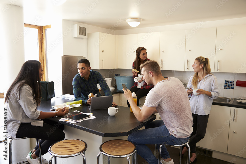 Students Relaxing In Kitchen Of Shared Accommodation Students Relaxing In Kitchen Of Shared Accommodation