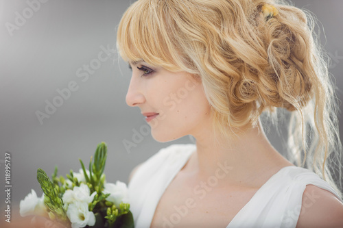 Happy young beautiful bride with a wedding bouquet.